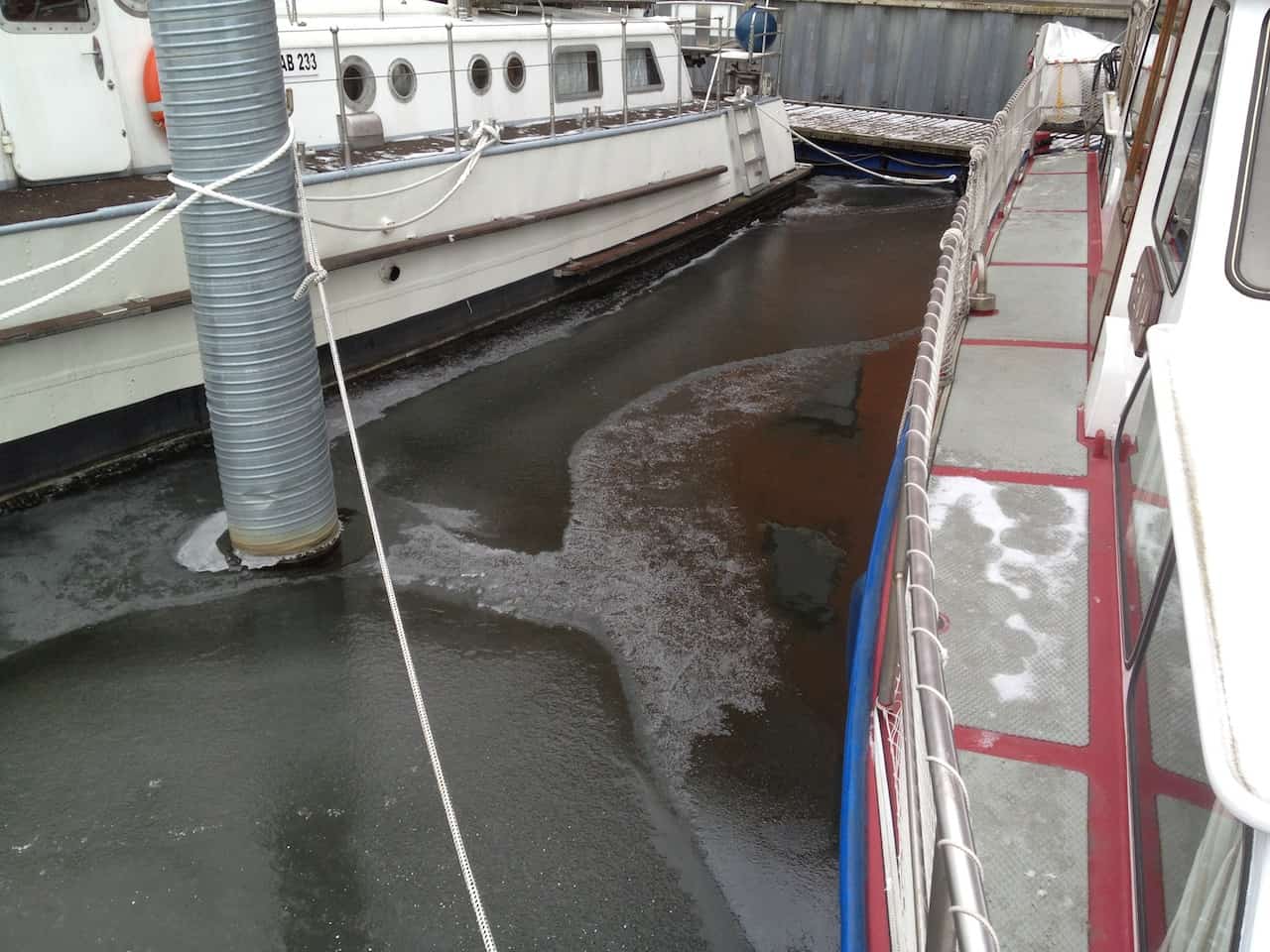 Boot überwintern im Wasser mit Eis im Hafen - aber dank Tauchpumpe fast eisfrei.