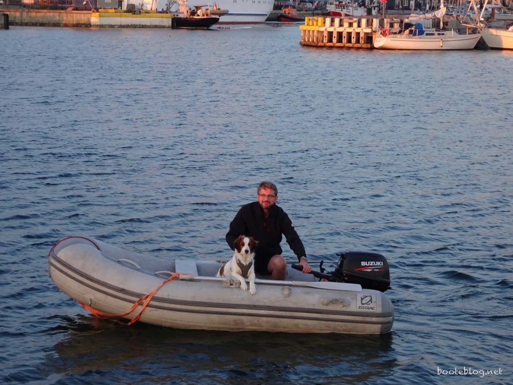 Der Skipper fährt mit seinem Bordhund an Land.