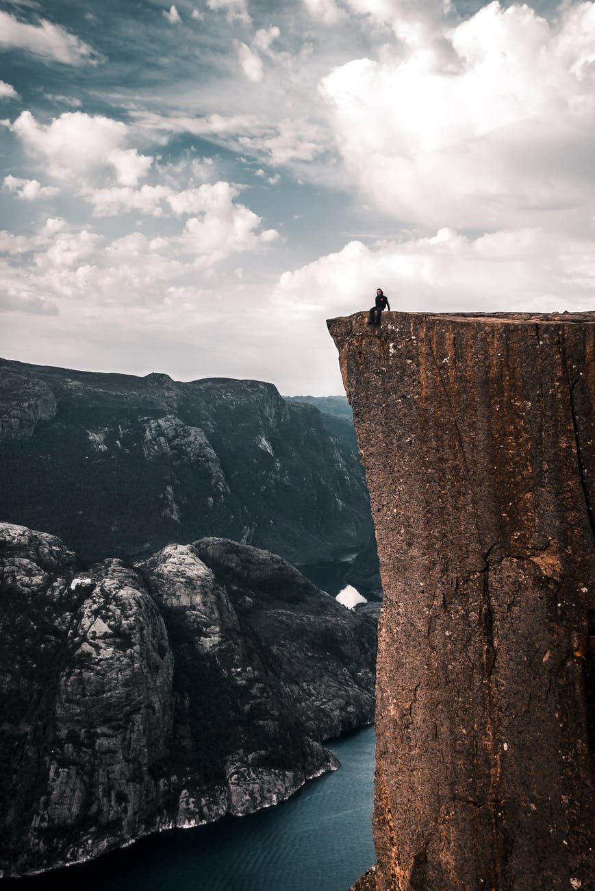 people sitting on the edge of a cliff